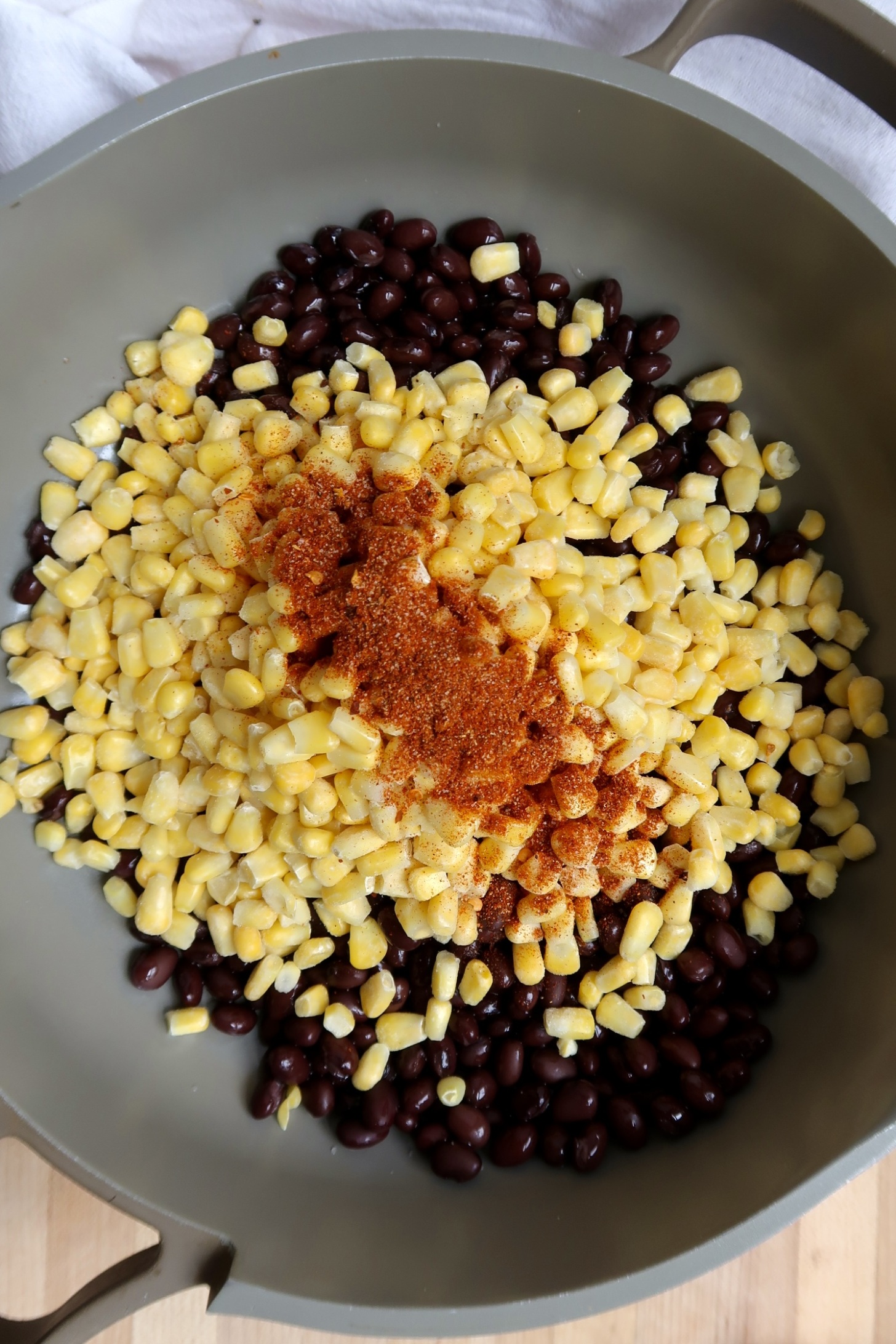 Pan with black beans and corn and seasoning on top.