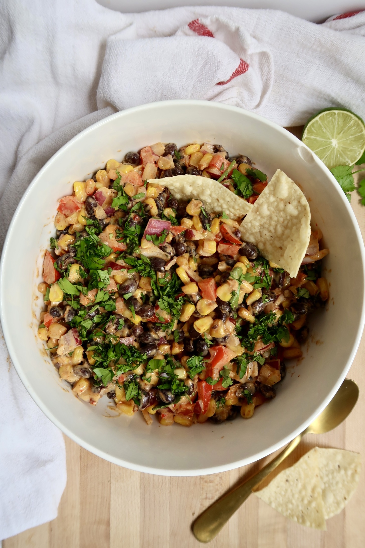 Bowl with black bean and corn salad with chips in it.