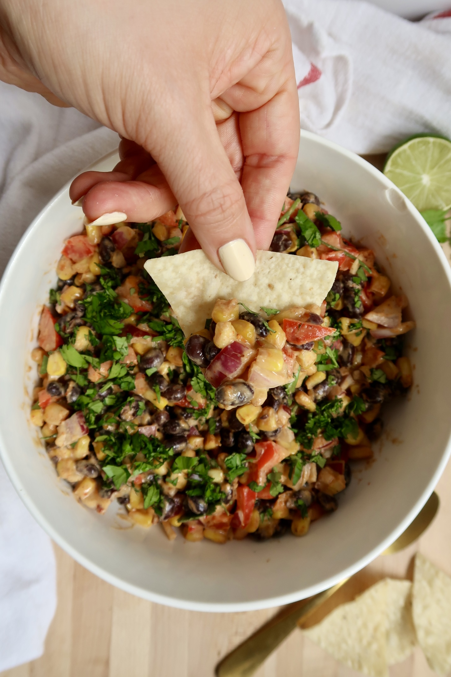 Corn chip being dipped in black bean and corn salad