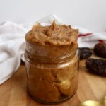Jar of date paste with dates in the background.
