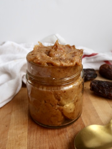 Jar of date paste with dates in the background.