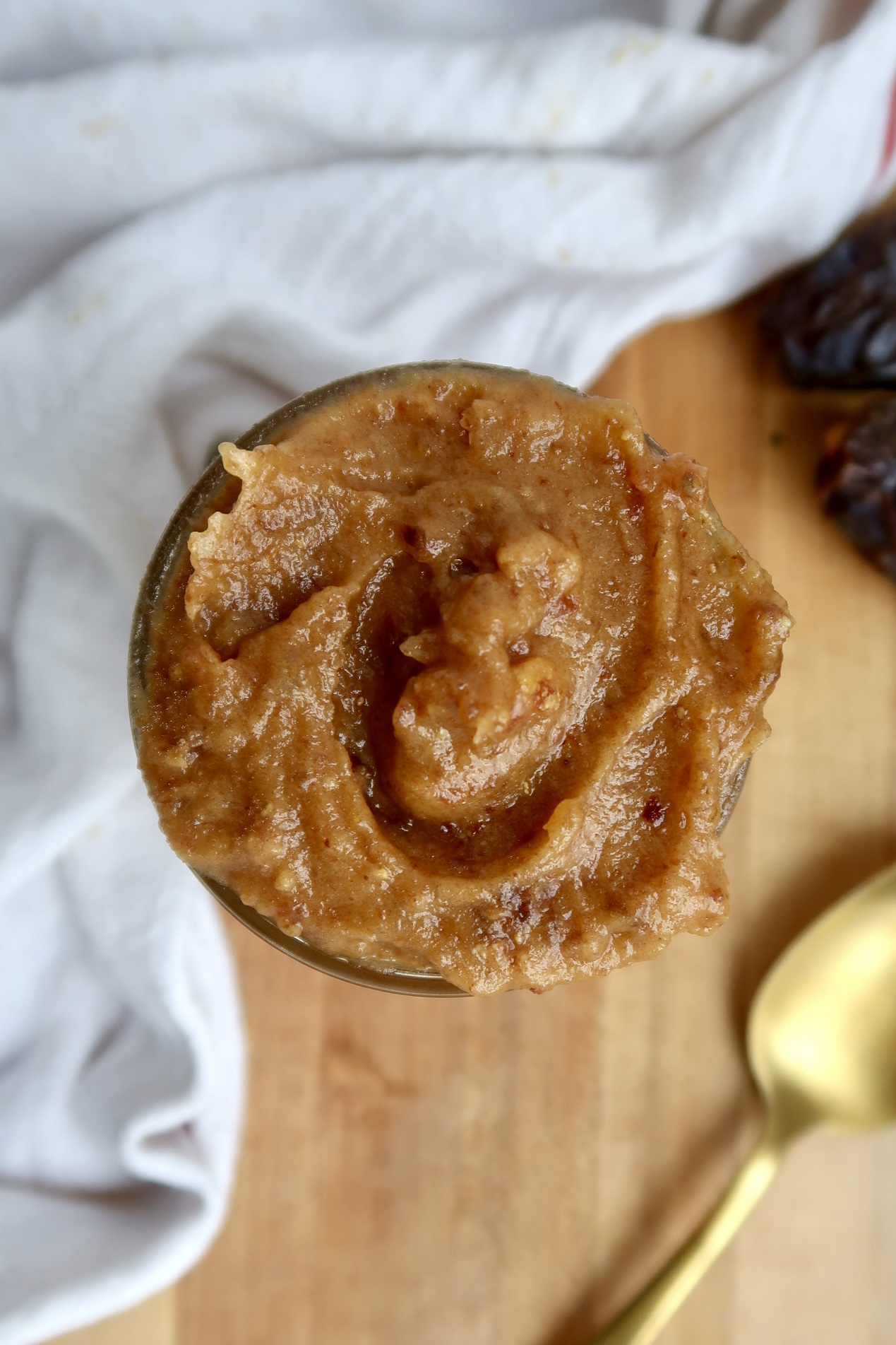 Overhead shot of jar of date paste with dates in the background.