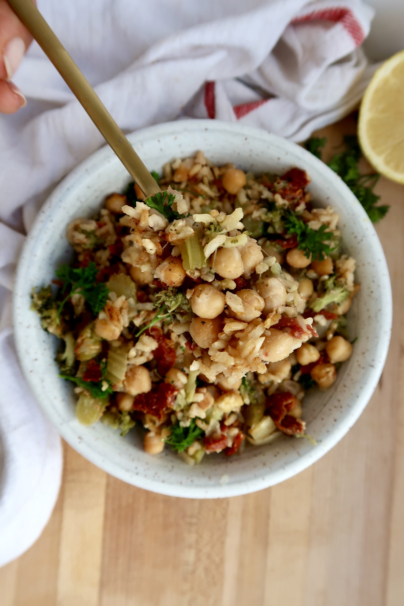 Overhead shot of chickpea casserole in a white bowl with a spoon scooping some.