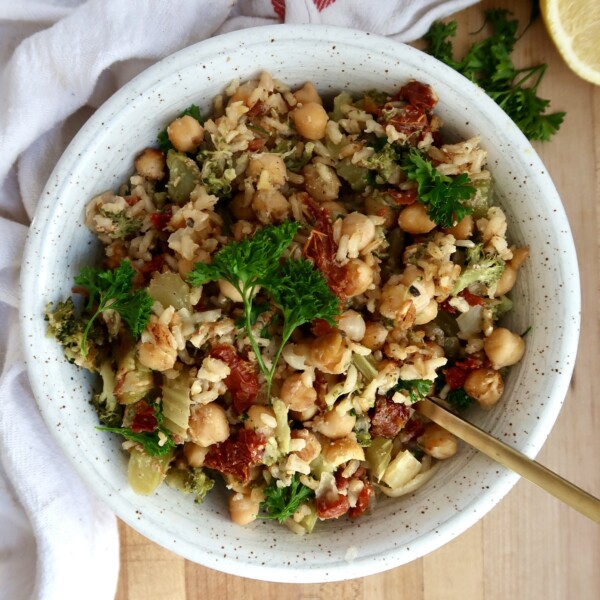 Chickpea casserole in a white bowl with a spoon scooping some.