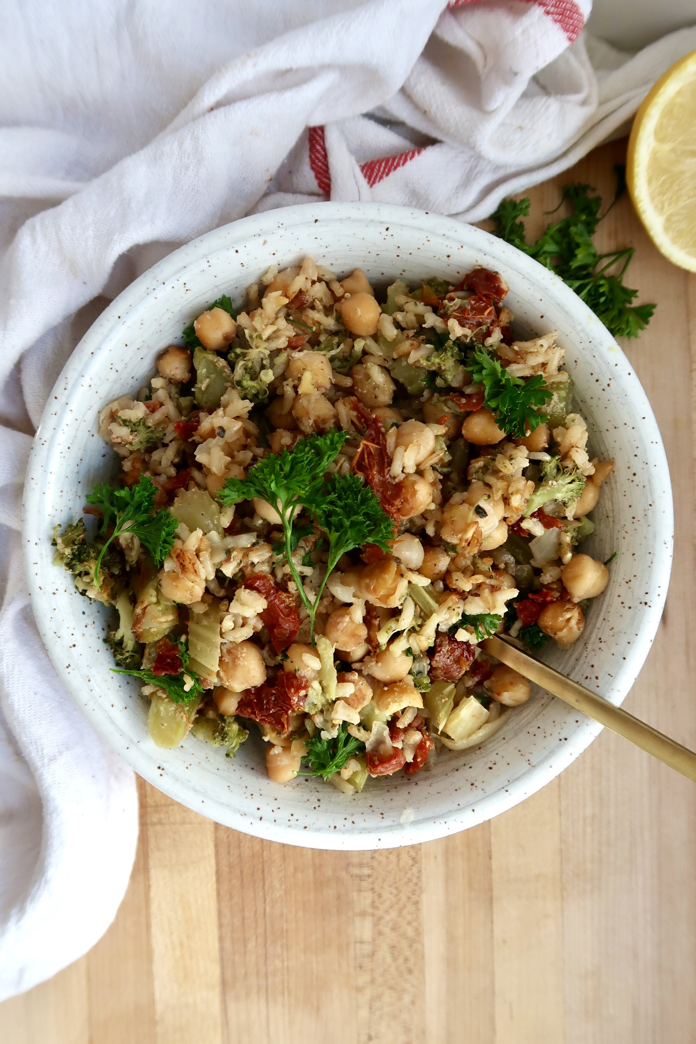 Chickpea casserole in a white bowl with a spoon scooping some.