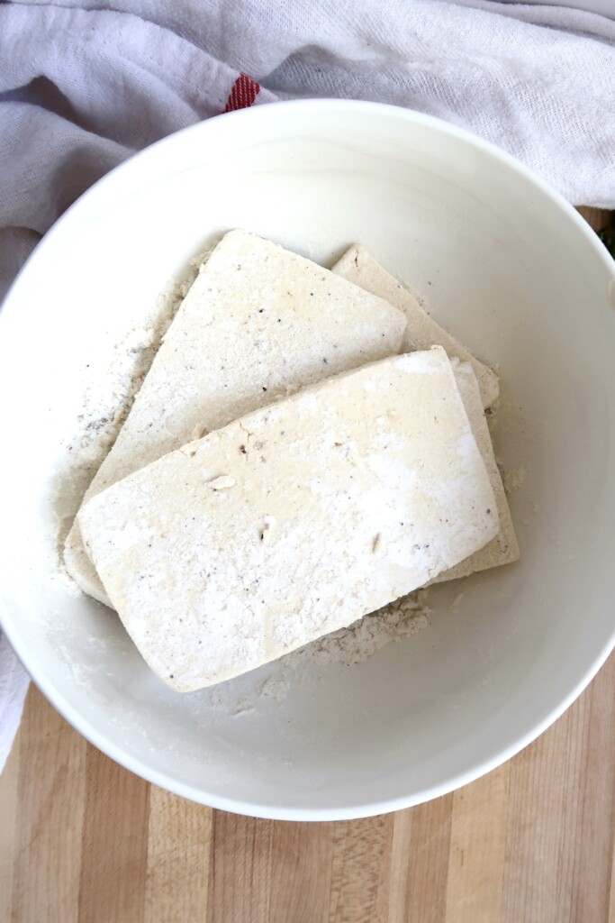 Bowl with flour with pieces of tofu in it.