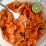 Shaved carrots with sesame seeds, parsley and lime with a fork spiraling some.