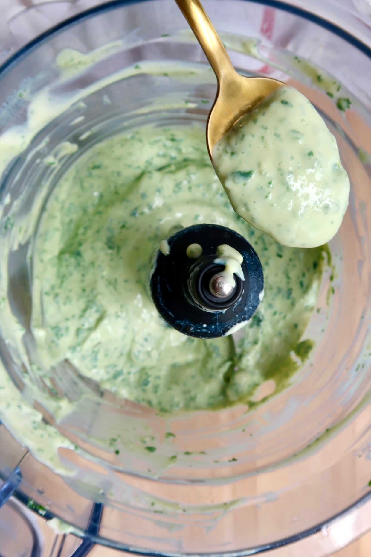 Food processor with tofu dip in it with a spoon.