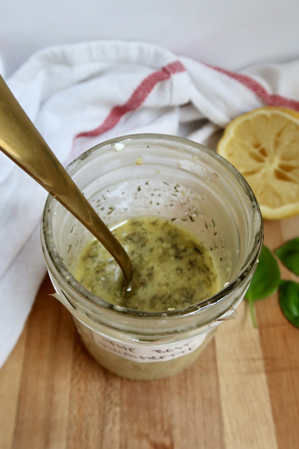 Overhead shot of the vinaigrette mixture inside the jar with a golden spoon