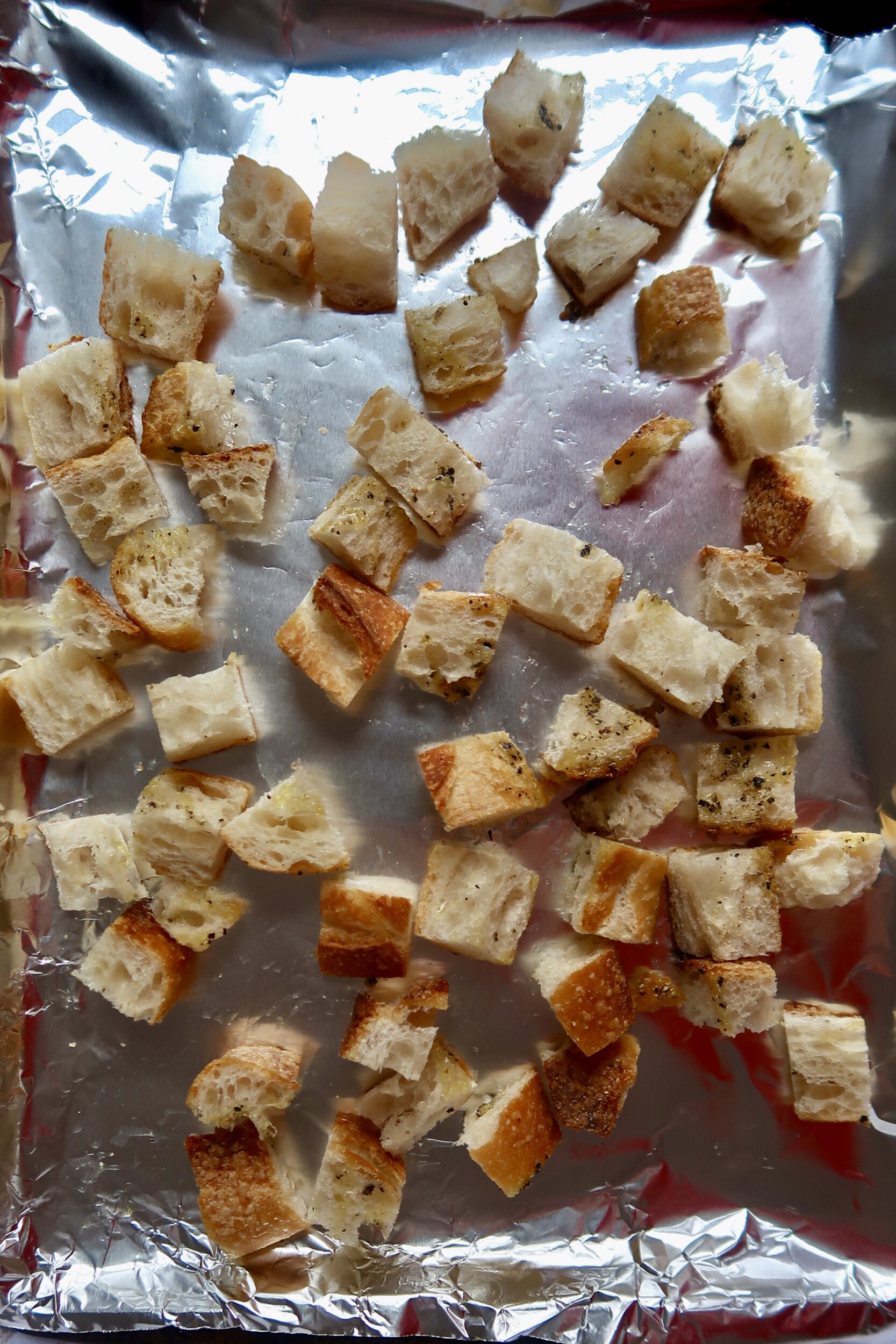 Croutons on a baking sheet – Toasted and evenly spread out, cooling after baking.