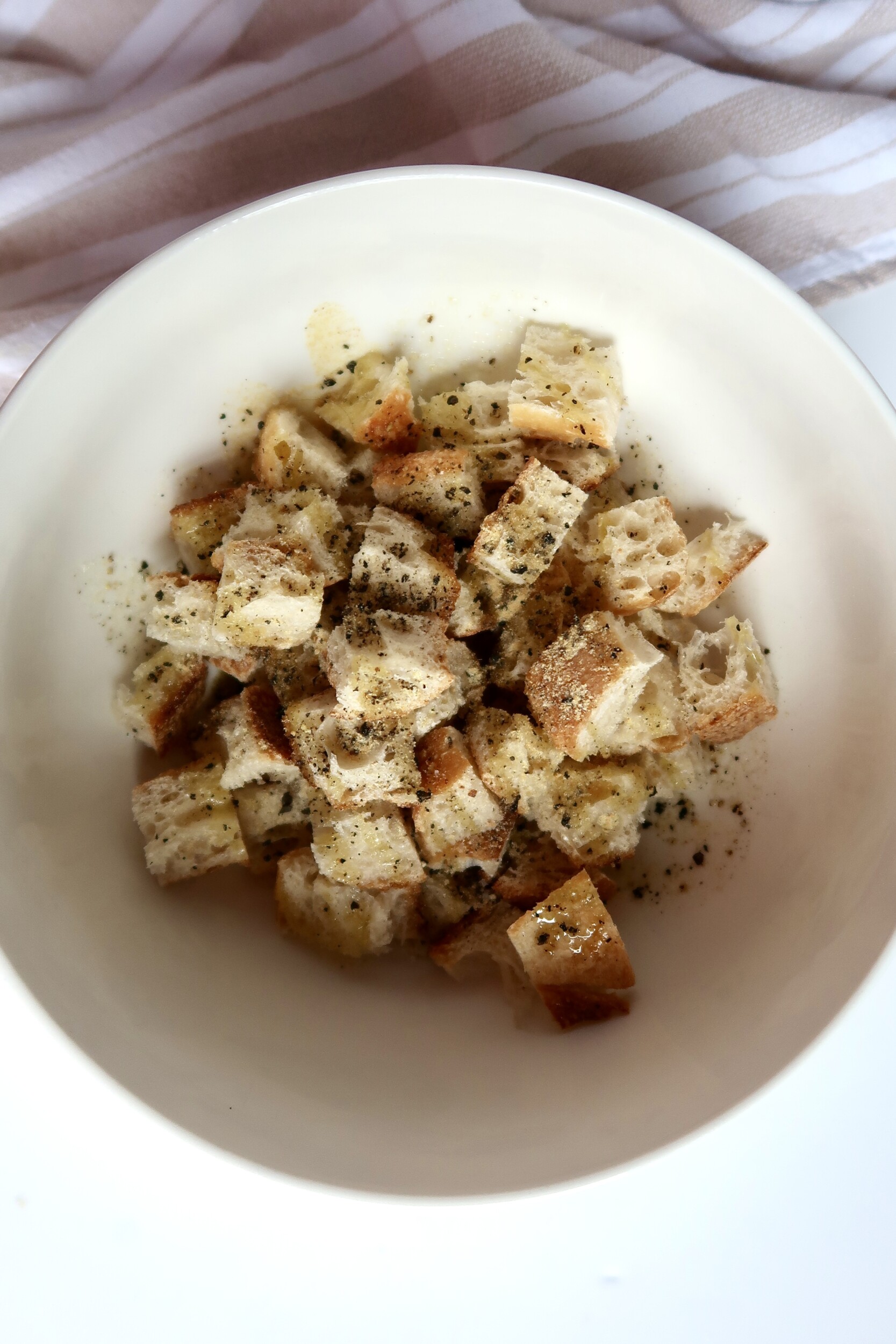 Croutons tossed with dried herbs and oil before cooking.