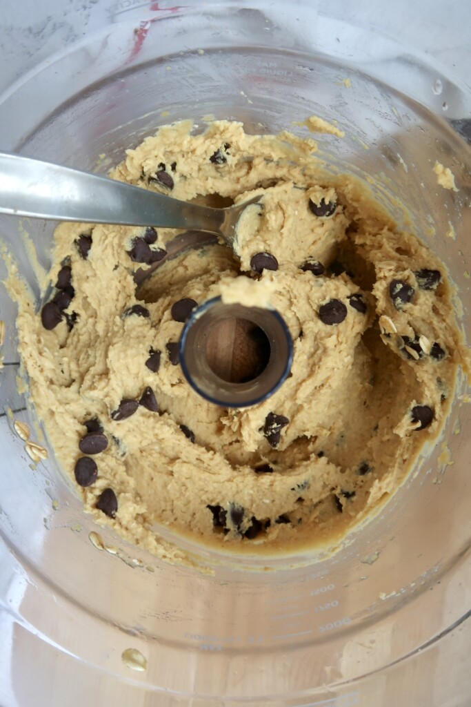 Food processor filled with chickpea cookie dough and chocolate chips.