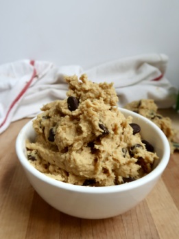 Bowl of chickpea cookie dough with chocolate chips on a white background.