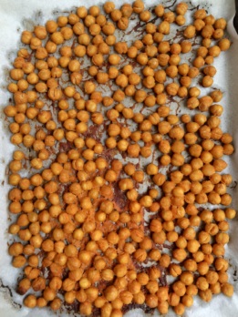 Overhead angle of roasted chickpeas on parchment paper.