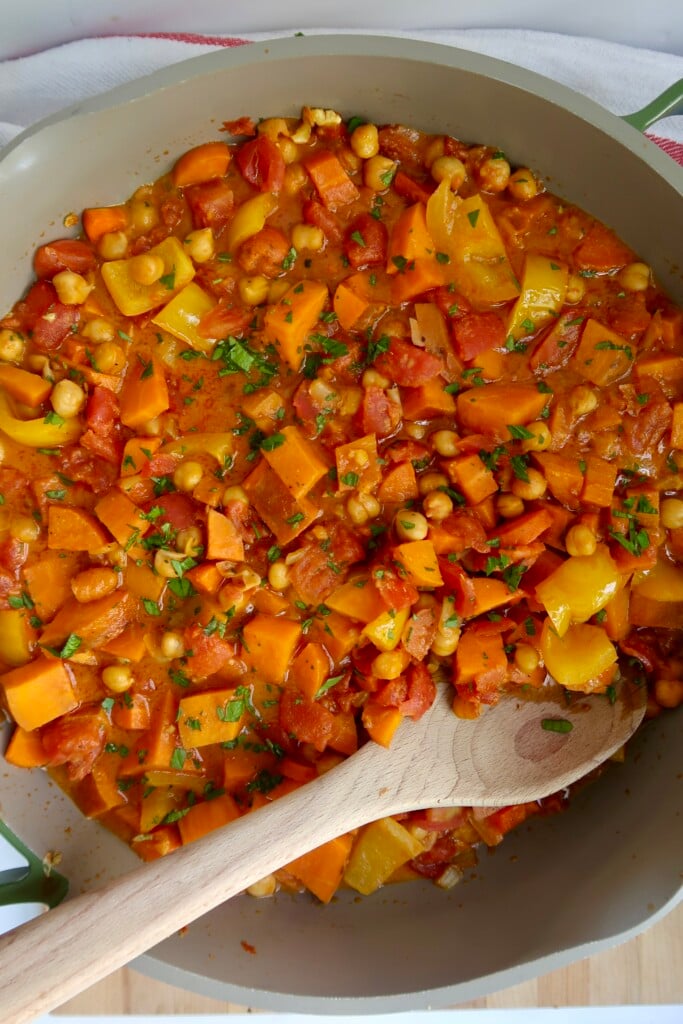 Curry in a pot with a wooden spoon.