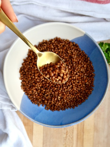Crispy lentils in a bowl with a spoon scooping some.