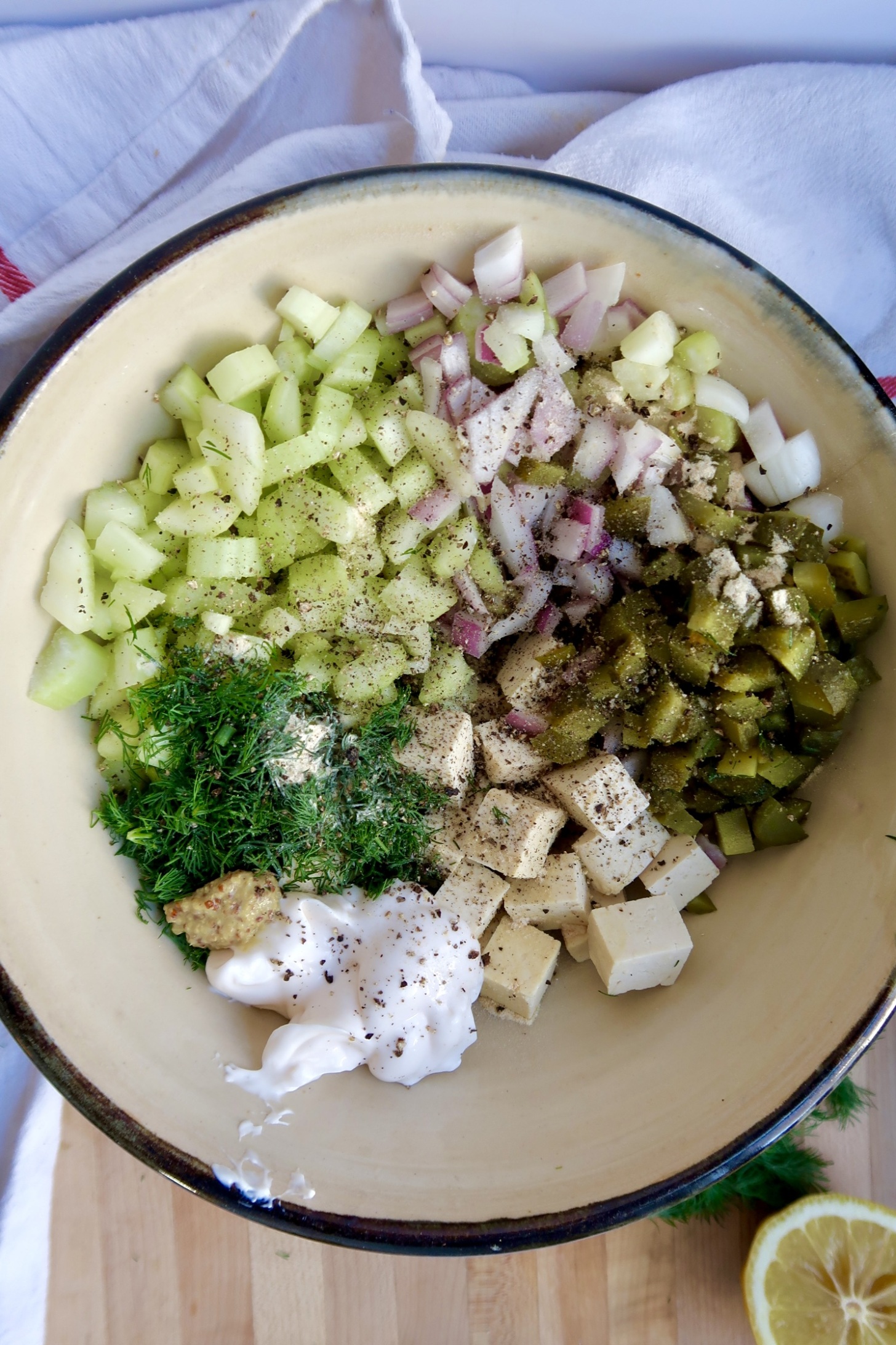 Bowl with cubed tofu, celery, red onion, pickles, dill, and mayo.