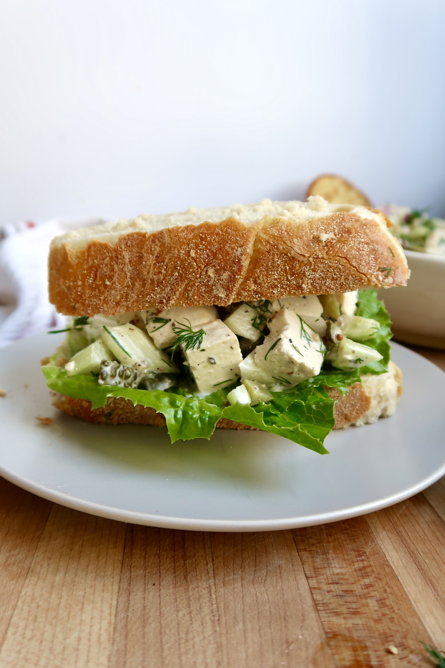 Tofu Salad Sandwich on crusty bread on a plate.
