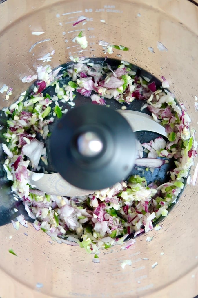 Food processor with onions, garlic and jalapeno chopped.